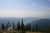 Bowman Lake overlook in Glacier National Park showing distant ridges, a calm lake, and evergreen silhouettes in the foreground.