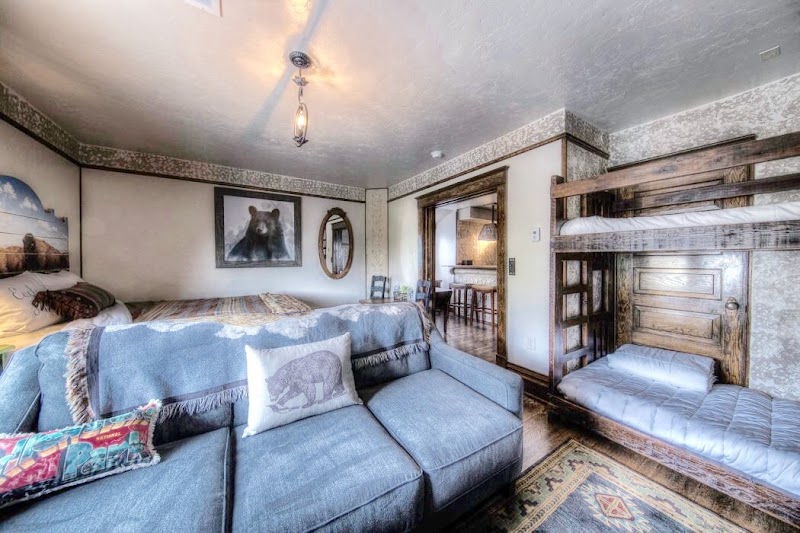 Cozy living area with a blue sectional, decorative pillows, a wooden bunk bed, and rustic decor in Yellowstone National Park.