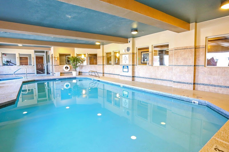 Indoor hotel pool area in Yellowstone National Park with a blue ceiling, beige tile walls, and a lifebuoy.