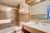Guest bathroom interior in a Yellowstone National Park lodge room, featuring beige tile and a large mirror.