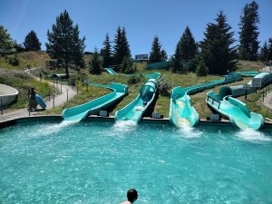 Turquoise multi-slide water park complex with winding slides at a Montana recreation area near Glacier National Park