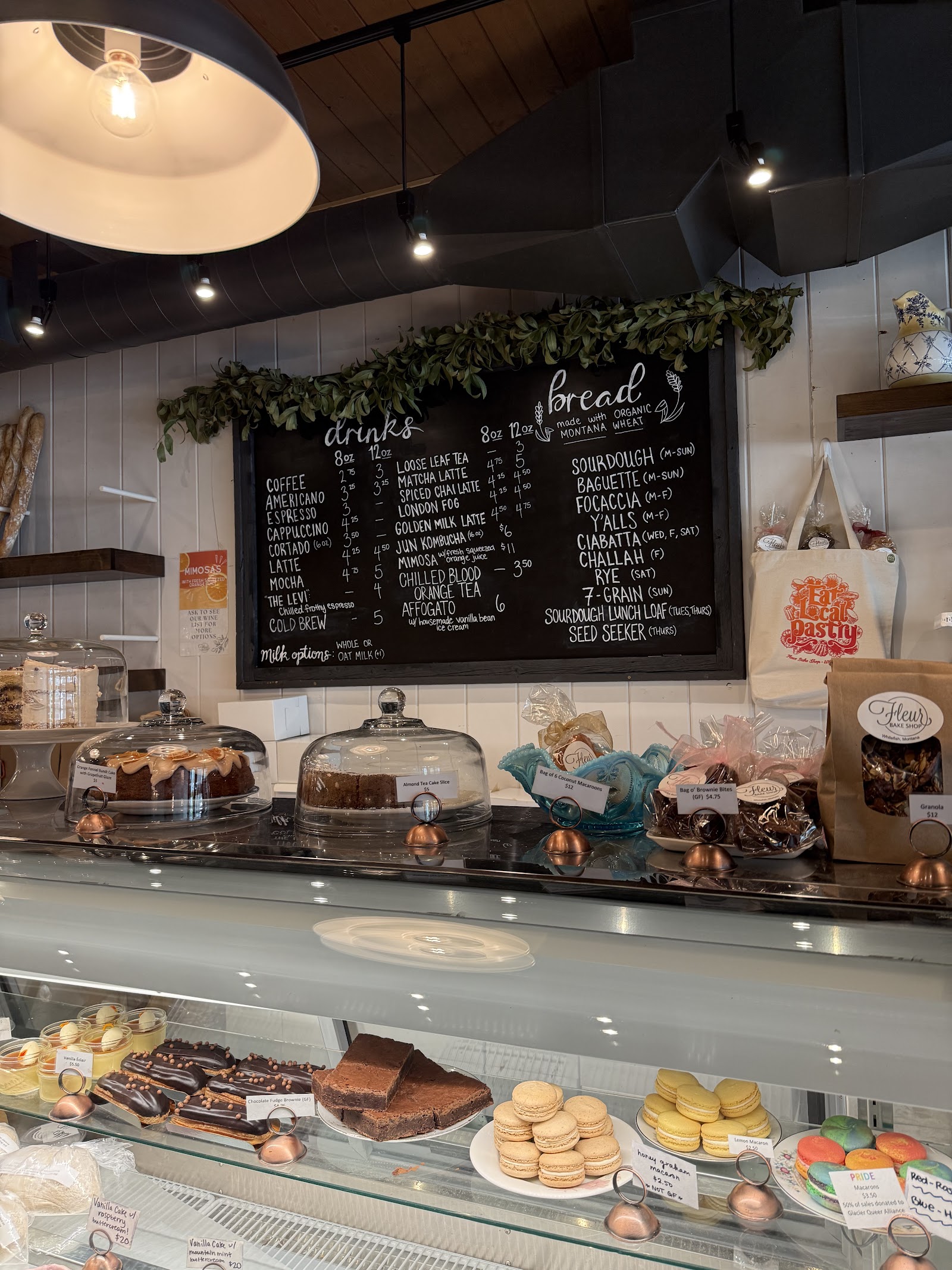 Interior of a Glacier National Park bakery with cakes and pastries on display behind glass cases.