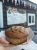 Close-up of a blueberry muffin in a paper tray inside a car, outside a Yellowstone cafe storefront.