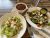 Romaine Caesar salad with croutons and a mixed greens salad with vegetables, plus a bowl of chili on a wooden table in Yellowstone National Park.