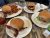 Three burgers with toppings and fries on a rustic table at Wonderland Cafe & Lodge in Yellowstone National Park