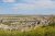 Badlands National Park panorama of eroded buttes and grassy flats with yellow wildflowers in the foreground.