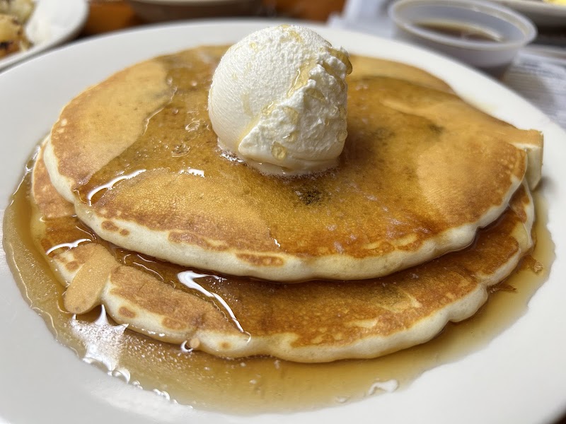 Golden pancakes drizzled with maple syrup, topped by a scoop of vanilla ice cream, served in Acadia National Park.