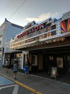 Criterion Theatre marquee along a storefront street in Bar Harbor near Acadia National Park, glowing with lights.