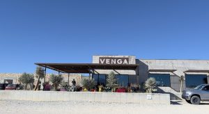 Desert restaurant exterior at Big Bend National Park near a gravel lot and palm plants.