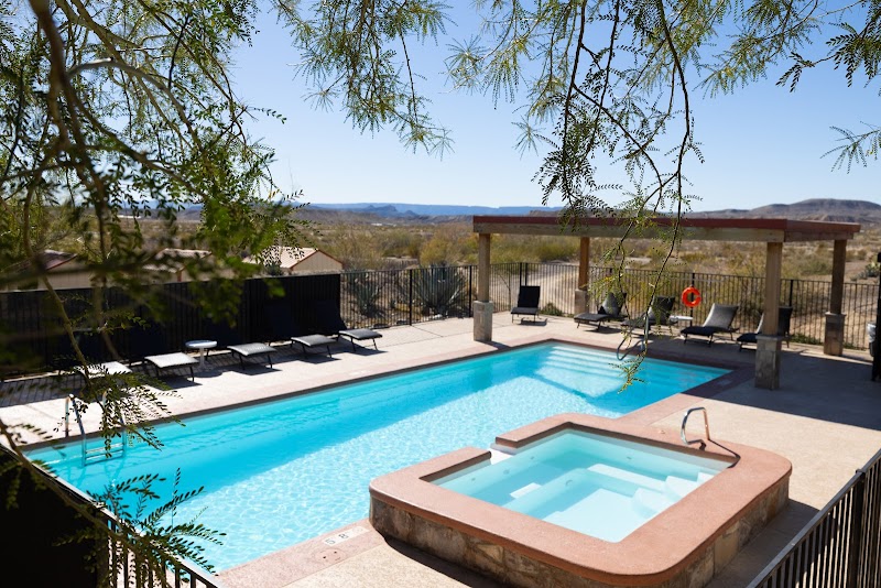 Pool and hot tub at a lodge in Big Bend National Park, with desert hills and blue sky in the background.