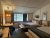 Lake Lodge cabin room in Yellowstone National Park featuring two queen beds, rustic wood accents, and forest-view windows.