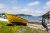 Yellow boat on a rocky shore beside a wooden dock at a harbor in Acadia National Park.