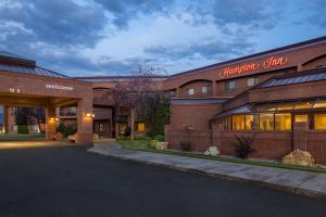 Exterior of a Kalispell lodging near Glacier National Park, showing brick arches, warm lighting, and a welcoming entrance at dusk.