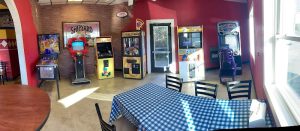 Inside a casual dining space in Acadia National Park, featuring arcade machines and blue-check tablecloths.