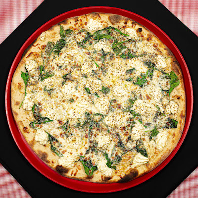 Cheesy pizza with greens served at a dining spot in Acadia National Park