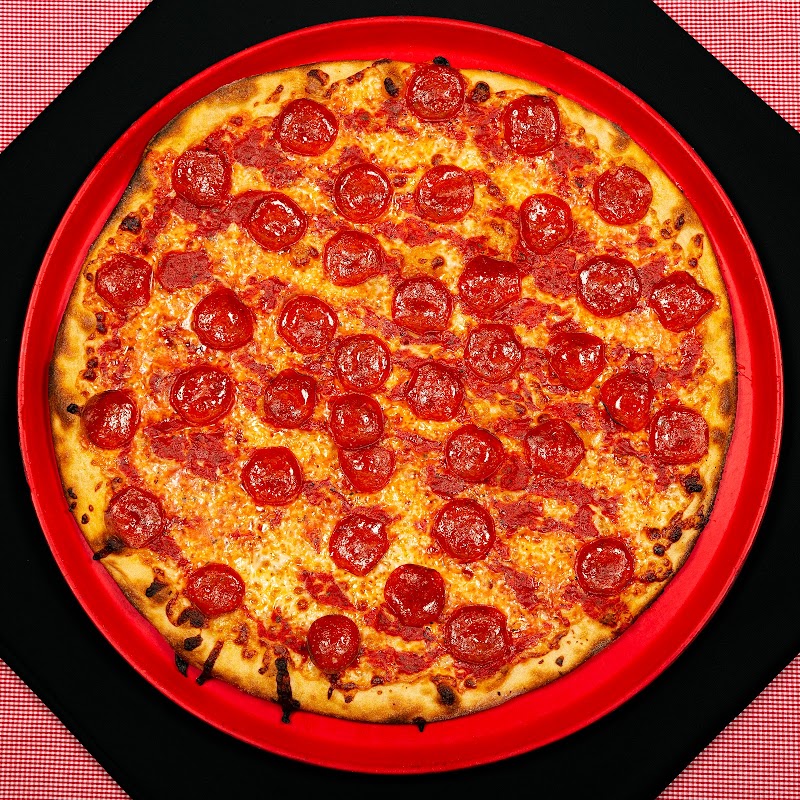 Pepperoni pizza served at a dining spot in Acadia National Park, displayed on a bright red plate.
