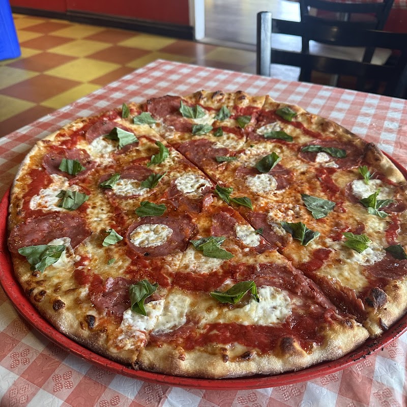Pizza at a cozy park restaurant in Acadia National Park, served on a red tray with a red-and-white checkered tablecloth.
