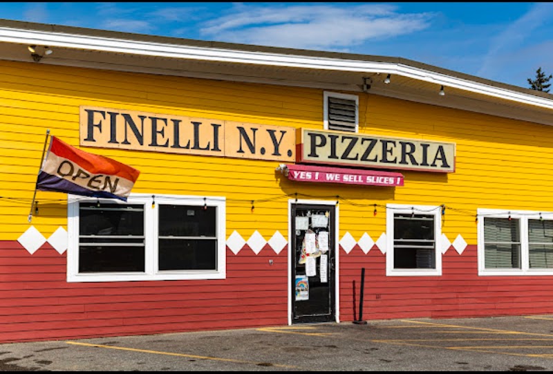 Colorful pizza shop storefront in Acadia National Park with bright yellow siding and red base.