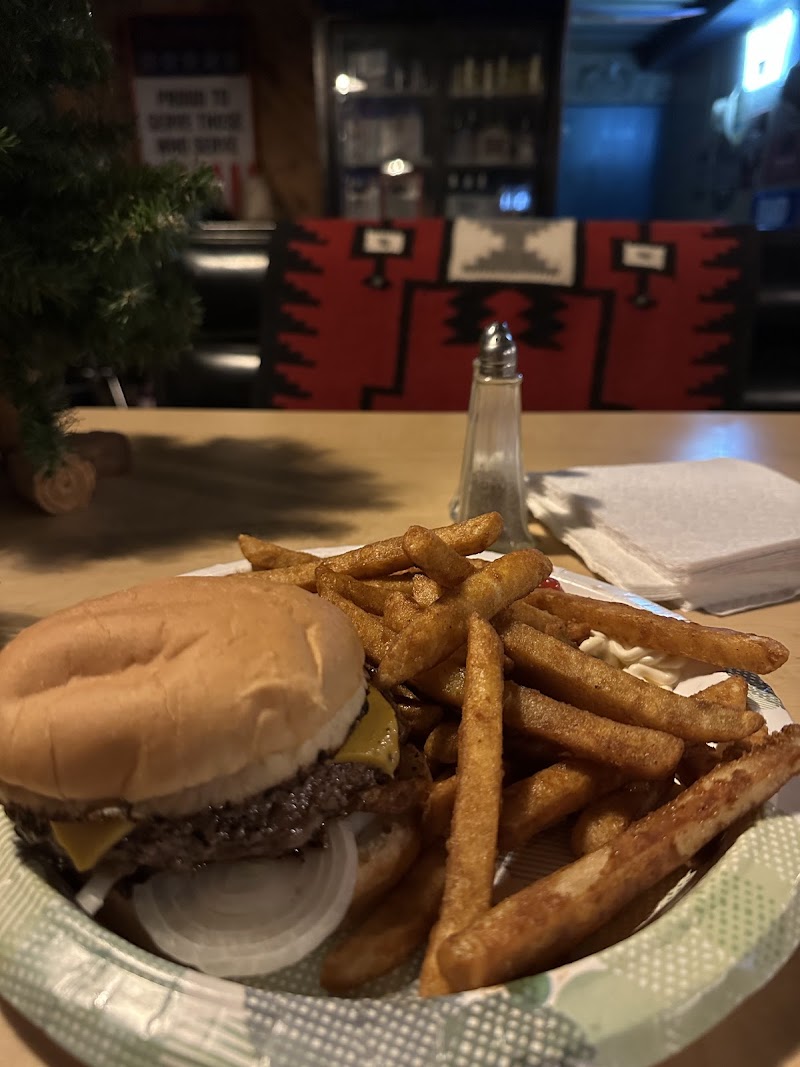Burger and fries with melted cheddar at a Badlands National Park dining spot, served in a casual indoor setting.