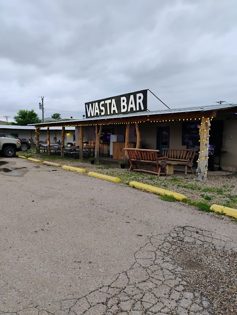 Exterior of a rustic roadside bar at Badlands National Park, with a covered porch and string lights.