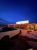 Brightly lit bar and restaurant exterior in Badlands National Park at dusk, with snow on the ground.