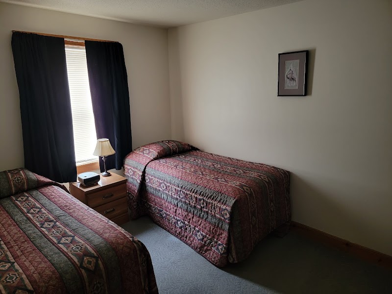 Two-bed guest room with a window and nightstand in Acadia National Park.