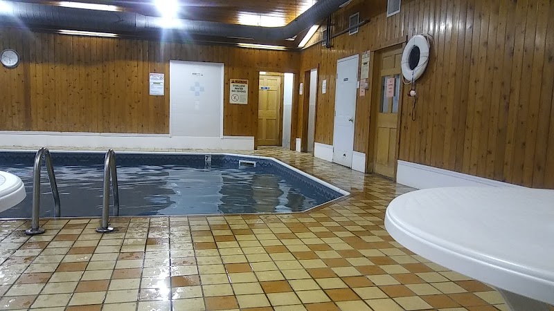 Indoor pool area inside a wooden lodge at Acadia National Park, with tiled floor and metal handrails.