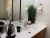 Bathroom vanity with a sink, kettle, mug, and a tall plant in Yellowstone lodging, a neat, modern bathroom scene.