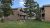 Yellowstone National Park cabin lodging with wood siding and balconies amid pine trees, a compact two-story complex.