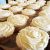 Rows of vanilla cupcakes with piped white frosting on a tray in a bakery kitchen at Yellowstone National Park.