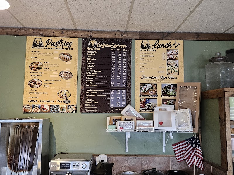 Yellowstone National Park cafe interior with green walls, three large menus for pastries, coffee, and lunch, and a shelf of boxes.