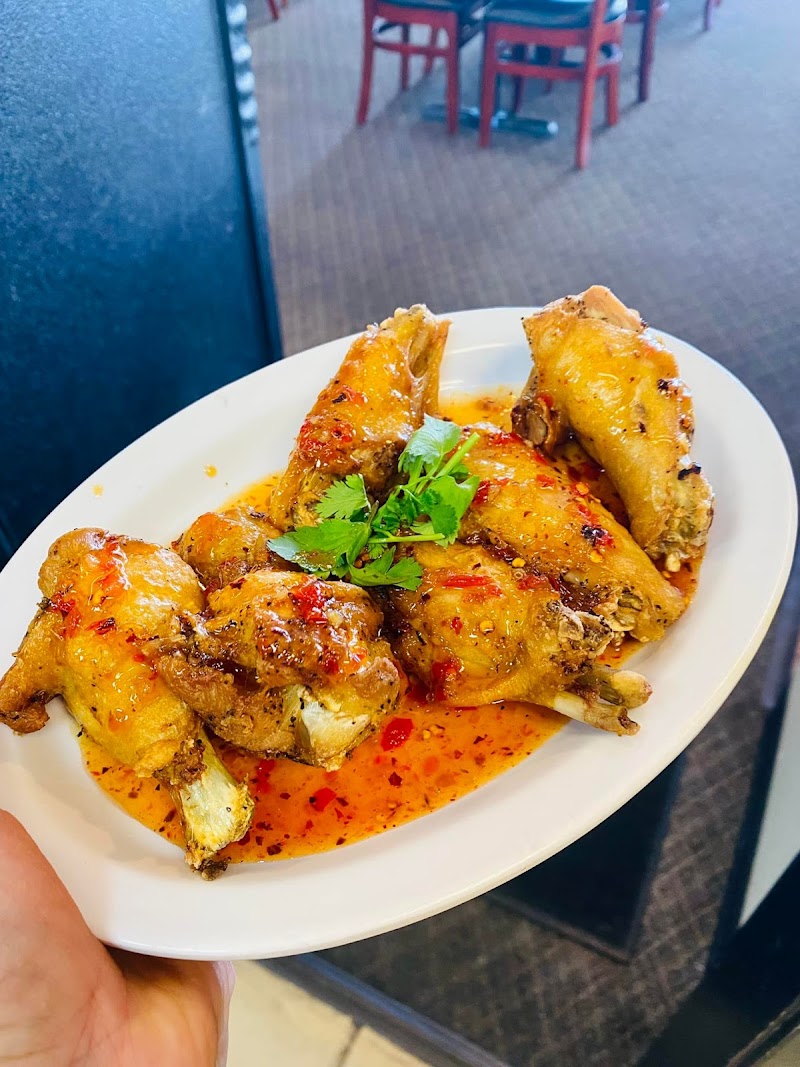 Plate of glazed chicken wings in spicy orange sauce with cilantro garnish, served at a casual restaurant near Arches National Park.