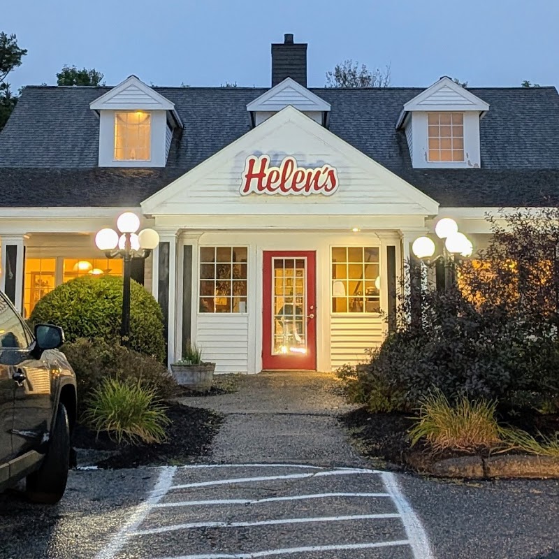 Front view of a white clapboard restaurant with a red door in Ellsworth, Acadia National Park at dusk.