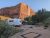 Grandstaff Campground at Arches National Park sits beneath towering red rock cliffs with RV and tent sites amid sage and juniper.