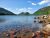 Jordan Pond Path Trailhead at Acadia National Park, showing clear lake, rocky shoreline, and forested mountains in the distance.