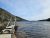 Jordan Pond Path Trailhead at Acadia National Park, a wooden boardwalk extending toward Jordan Pond beside rocky shores under a blue sky.