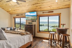 Guest bedroom with lake view and large windows in Glacier National Park.