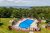 Outdoor pool at Bar Harbor lodging with views toward Acadia National Park’s coastline and surrounding trees.