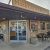 Brick storefront with glass doors, outdoor tables, string lights, and an open sign in Arches National Park.