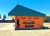 Exterior of a roadside motel in Yellowstone National Park with a bright orange wall, green roof, and a mountain mural.