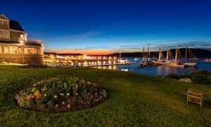Sunset over Bar Harbor harbor near Bar Harbor Inn, Acadia National Park, with moored schooners and calm water.
