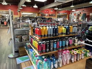Inside a gift shop at Cadillac Mountain in Acadia National Park, shelves display colorful water bottles and outdoor gear.
