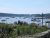 Harbor scene at Acadia National Park with small boats, lobster pots, a wooden pier, and seaweed-lined foreground.