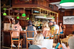 Interior view of a rustic bar inside Acadia National Park, with patrons seated along the wooden counter.