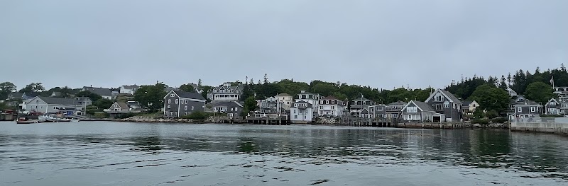 Stonington harbor waterfront with pastel houses lining the shoreline in Acadia National Park.
