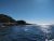 Egg Rock Lighthouse at Acadia National Park sits along the rocky shoreline under a clear blue sky.