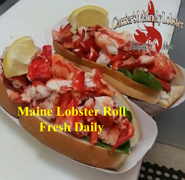 Two lobster rolls with lemon wedges on a white tray at a Bar Harbor seafood spot near Acadia National Park.