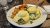 Two eggs Benedict with spinach and hollandaise on toasted bread, served with cubed breakfast potatoes at a Yellowstone cafe.