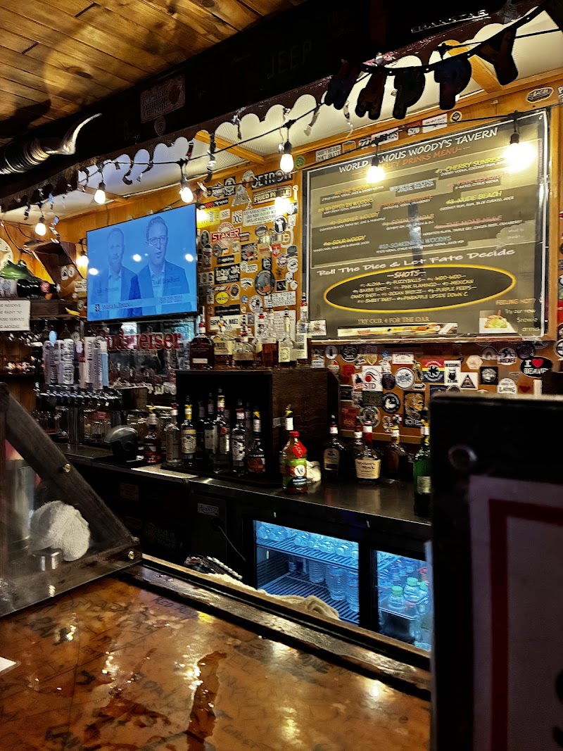 Inside Arches National Park, a wood-paneled tavern bar with string lights, a chalkboard menu, and beer bottles behind the counter.