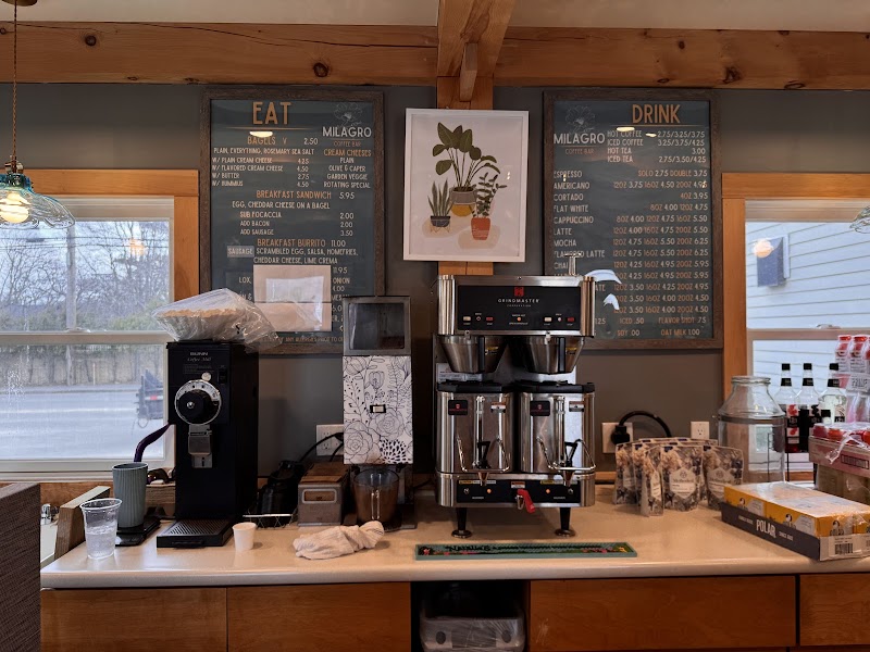 Inside a cafe counter with a large espresso machine, menu boards, and a coffee grinder at Acadia National Park.